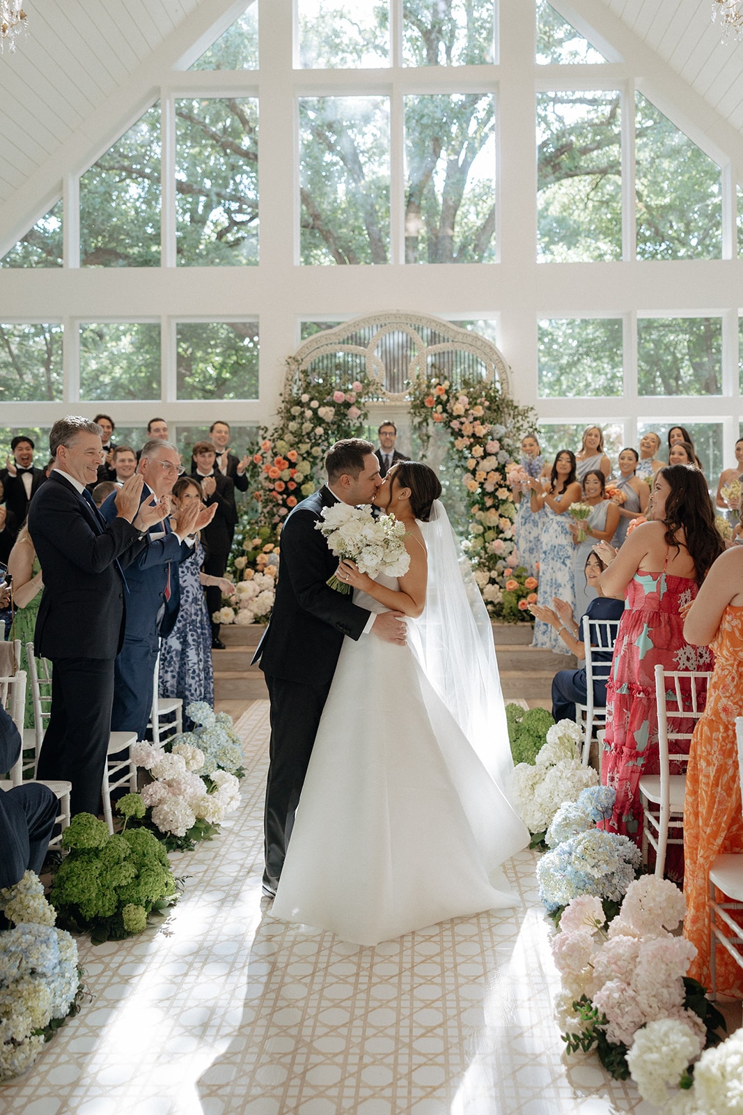 Ally and Drew's first kiss in the chapel aisle surrounded by overflowing hydrangea baskets and cheering guests