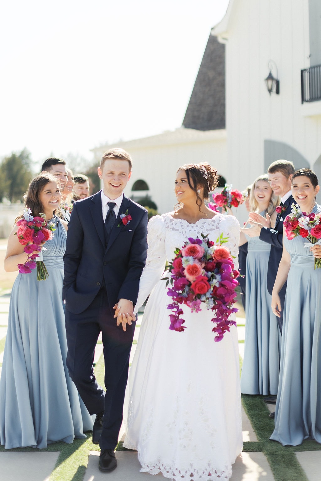 Katherine and Hayden walking with their full wedding party outside the venue